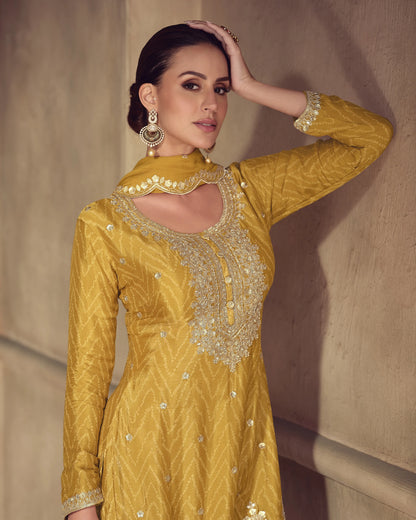 Woman wearing a mustard yellow embroidered dress against a neutral background