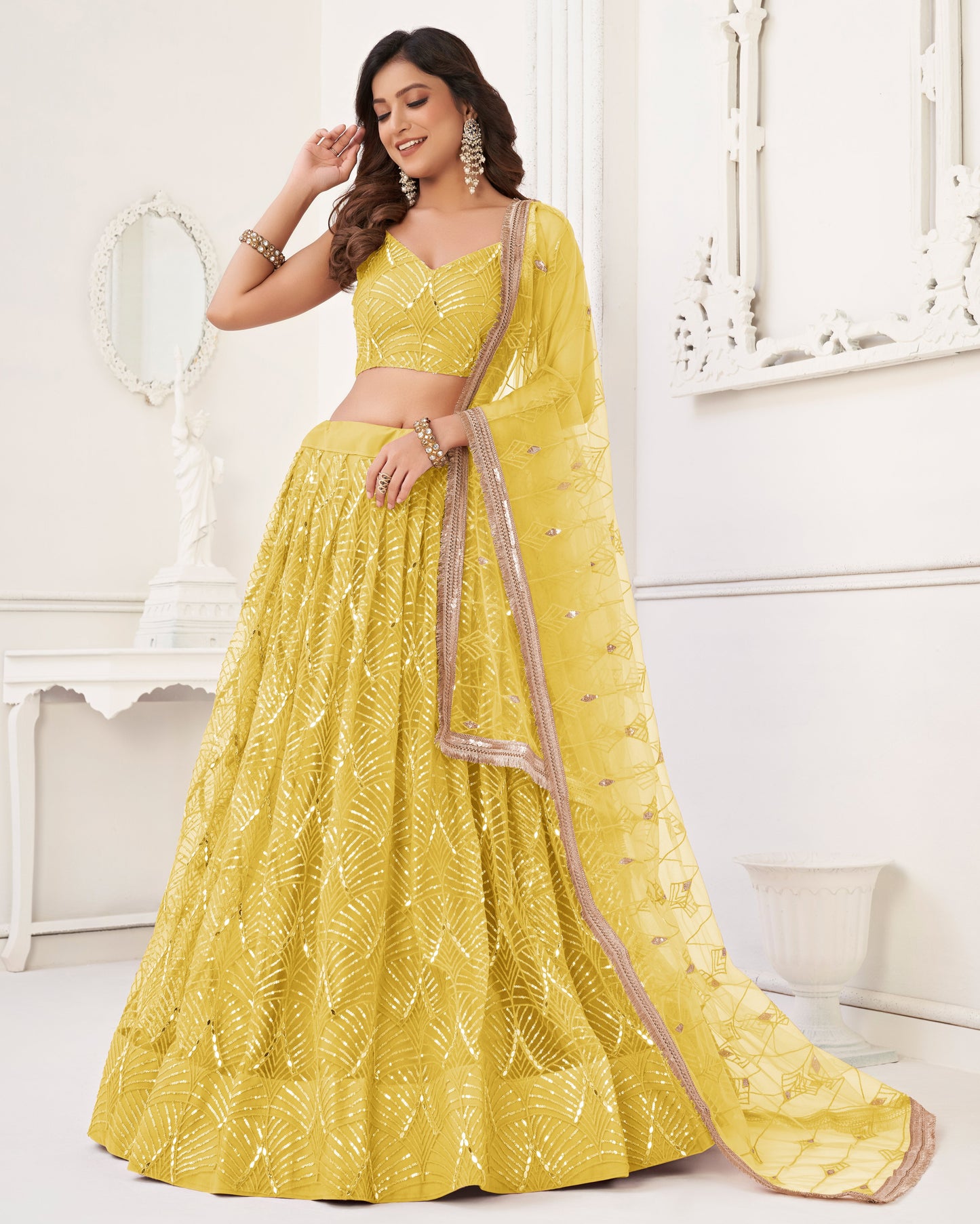 Woman wearing a yellow embroidered saree with a white background