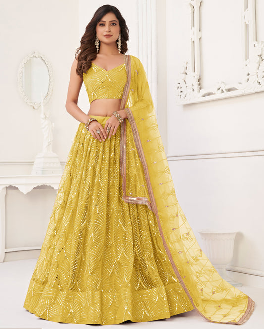 Woman wearing a yellow embroidered lehenga with a white background