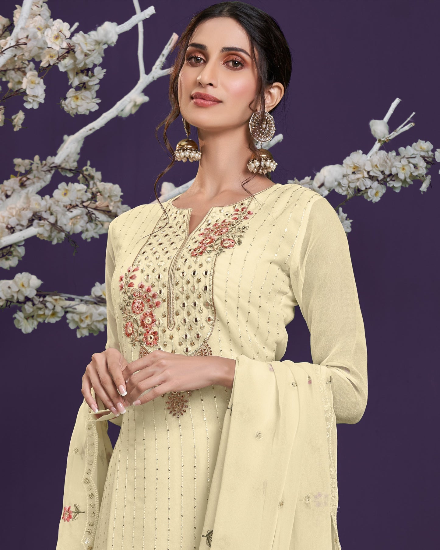 Woman wearing a light yellow embroidered traditional outfit with a floral background