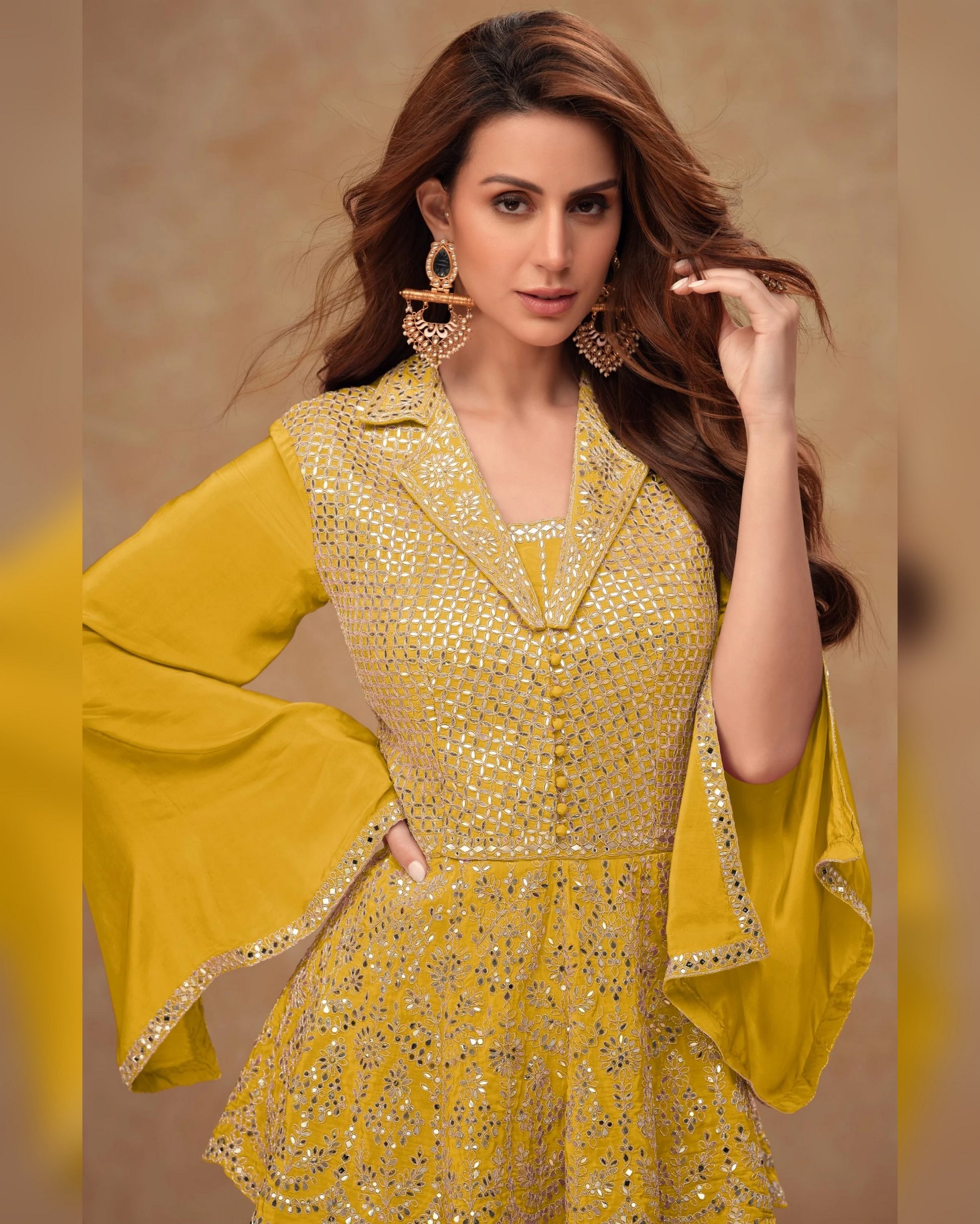 Woman wearing a yellow traditional outfit with intricate designs on a beige background