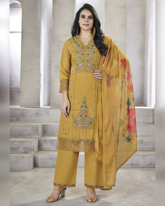 Woman wearing a mustard yellow embroidered outfit with a floral dupatta on a neutral background