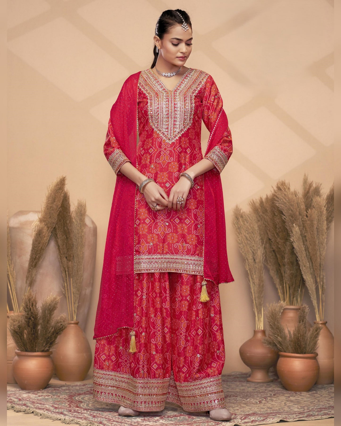 Woman wearing a red traditional outfit with intricate patterns in a decorative setting.