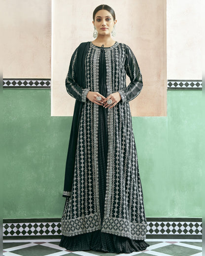 Woman wearing a black and white patterned dress against a green and beige wall.