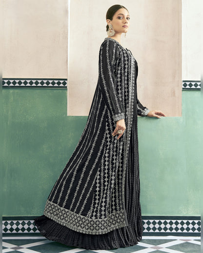 Woman wearing a black and white patterned dress against a decorative wall.