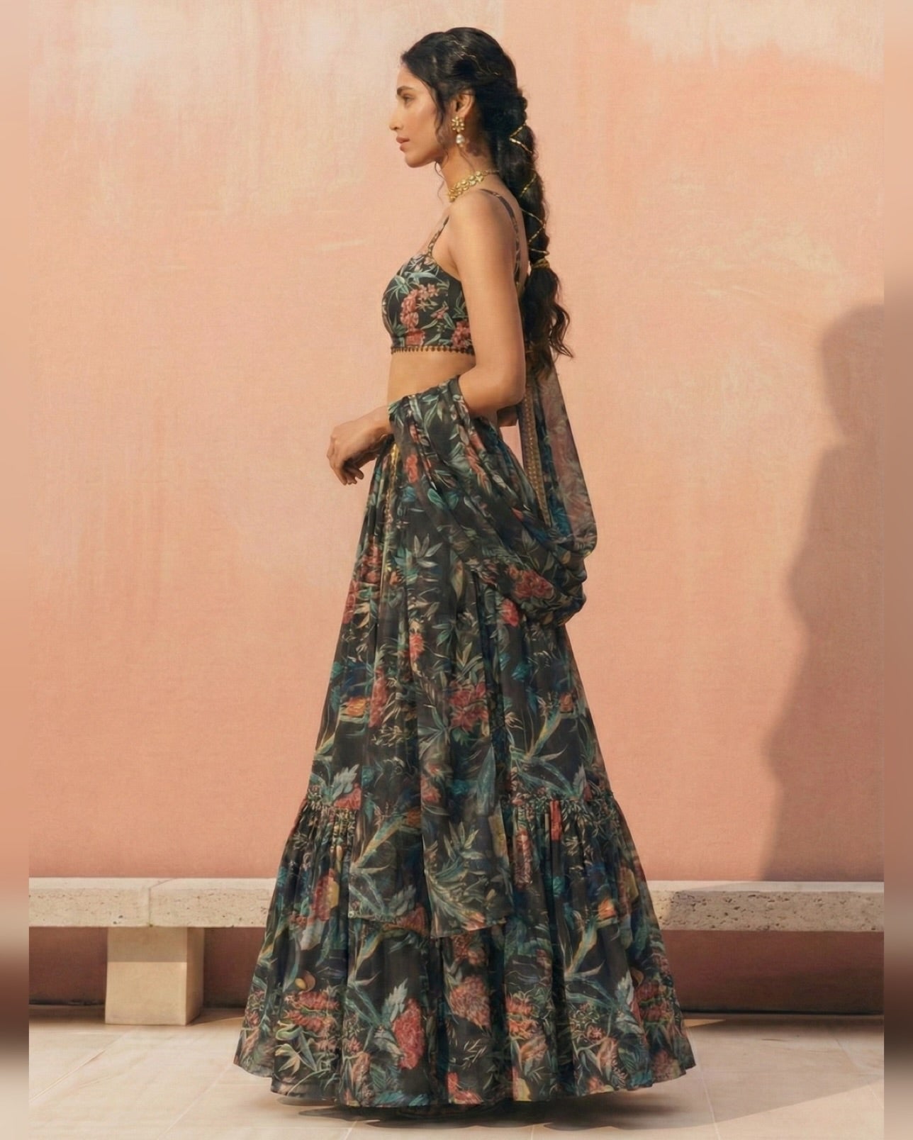 Woman wearing a floral dress against a pink wall