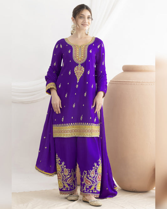 Woman wearing a purple embroidered outfit with gold details on a white background