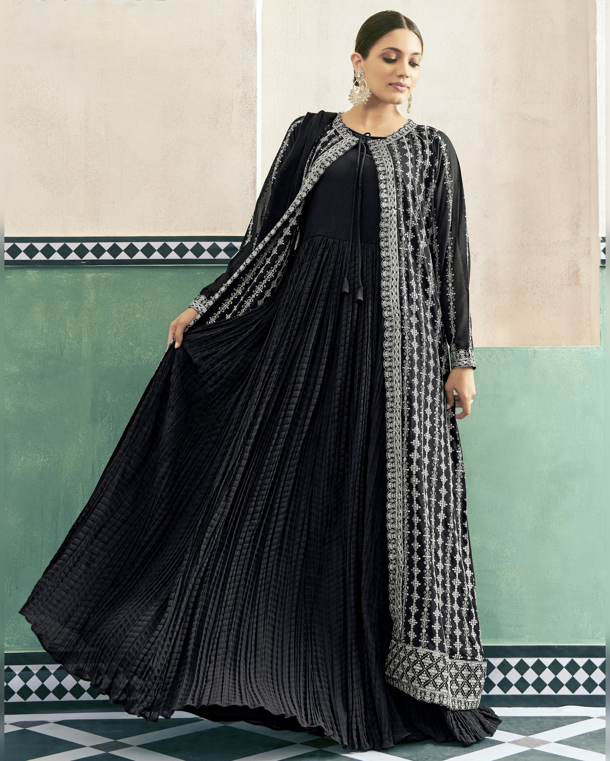 Woman wearing a black and white patterned dress with a matching shawl in a decorative interior setting.