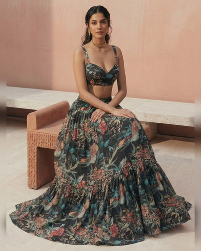 Woman wearing a floral dress sitting on a bench with a pink wall background