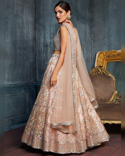 Woman in a traditional embroidered outfit standing in a room with ornate furniture.