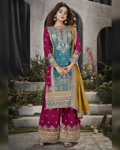 Woman wearing a traditional embroidered outfit with a teal and pink design.