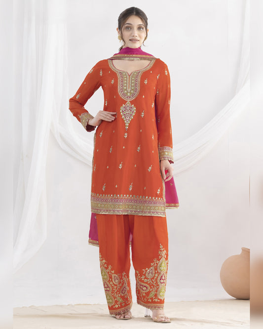 Woman wearing an orange embroidered traditional outfit with a white background