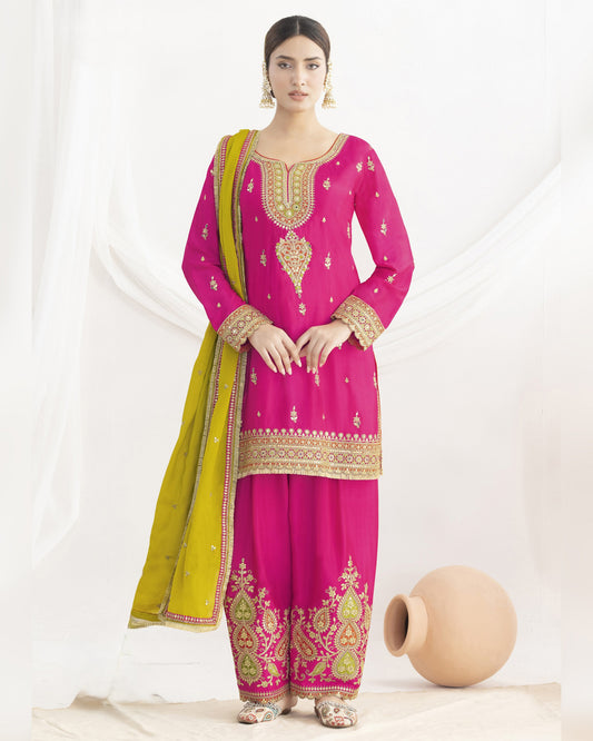 Woman wearing a pink embroidered traditional outfit with a green dupatta on a white background