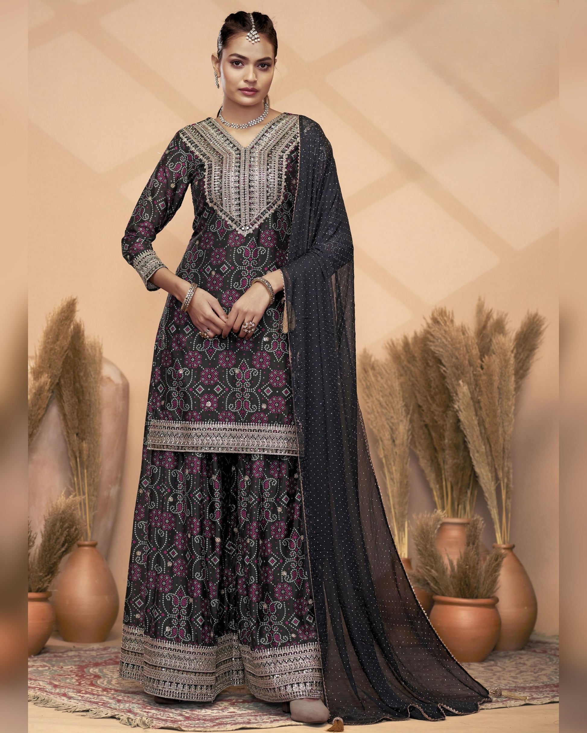 Woman wearing a traditional outfit with intricate patterns in a decorative setting.