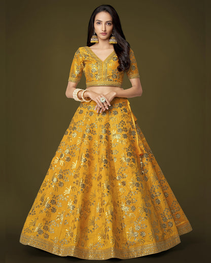 Woman wearing a yellow embroidered traditional outfit on a dark background